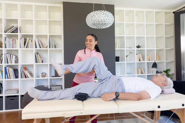 Chiropractor stretching a senior patient's leg during extremity rehabilitation at The Shift Oakland