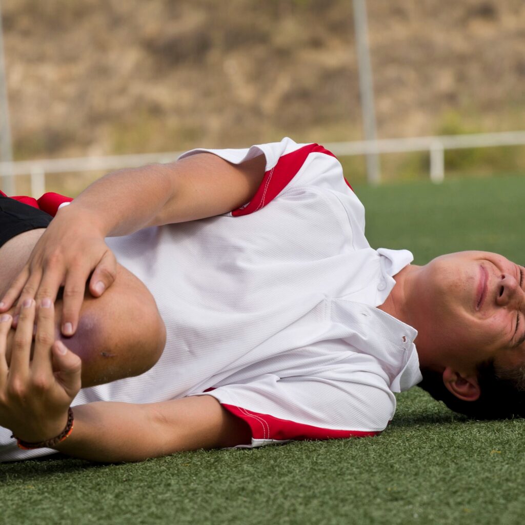 Athlete holding knee in pain — sports injury recovery at The Shift Chiropractic Oakland