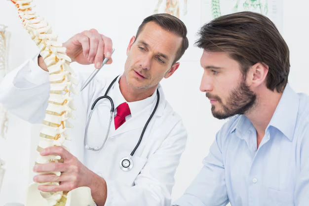 Doctor explaining spinal disc injury using a spine model at The Shift Chiropractic Oakland