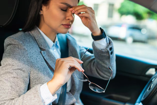 Woman experiencing a post-accident headache in her car — headache relief Oakland chiropractic