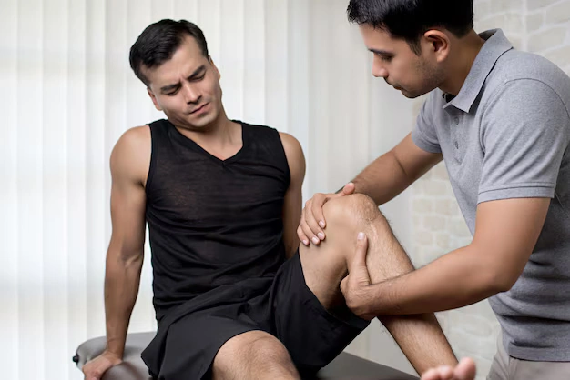 Chiropractor treating an athlete's knee injury at The Shift Chiropractic in Oakland